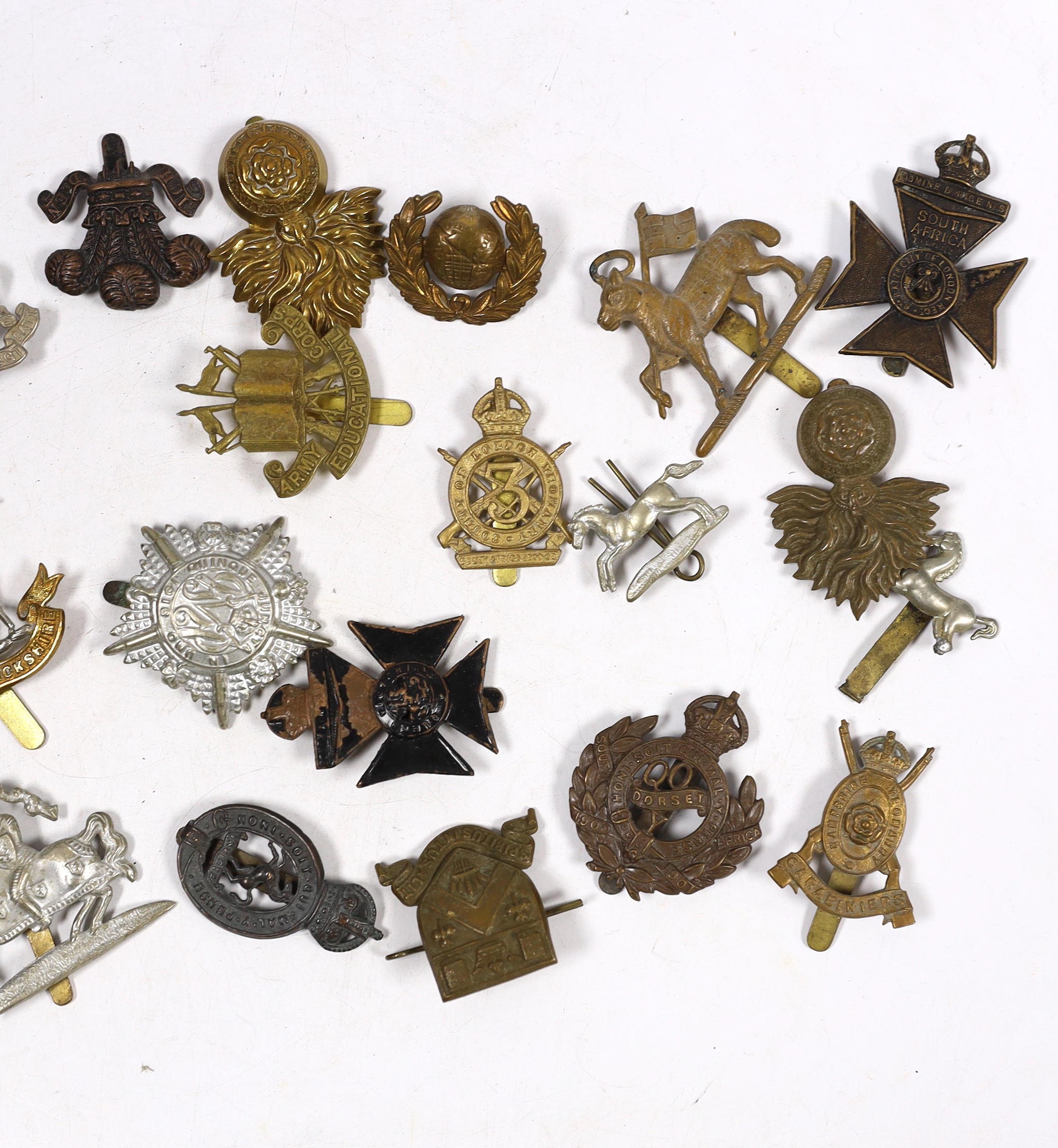 Thirty military cap badges including Royal Warwickshire, Hampshire Yeomanry Carabiniers, Inniskillin, Royal Canadian, AMC, Dorset, Army Educational Corps, London and West Rifle Volunteers, etc.